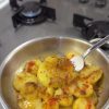 Sliced breakfast potatoes cooked in a pan with butter, thyme, and paprika, served hot.