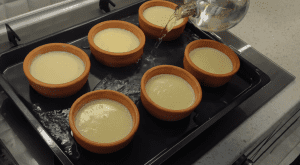 Rice pudding ramekins in a water bath (Bain-Marie) inside the oven for a creamy consistency.