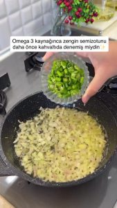 Adding chopped green peppers to the skillet with softened onions.