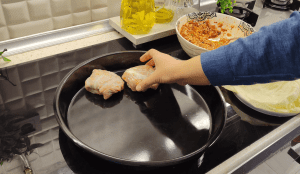 Adding 3 tablespoons of rice and meat filling into the cabbage-lined bowl.