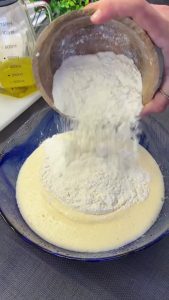 Whisking eggs, sugar, and vanilla in a mixing bowl until the mixture becomes pale and foamy.