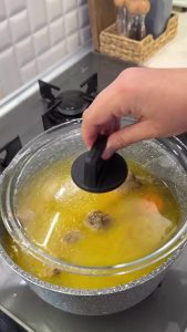 Dropping large chunks of potatoes into the simmering chicken and carrot stew.