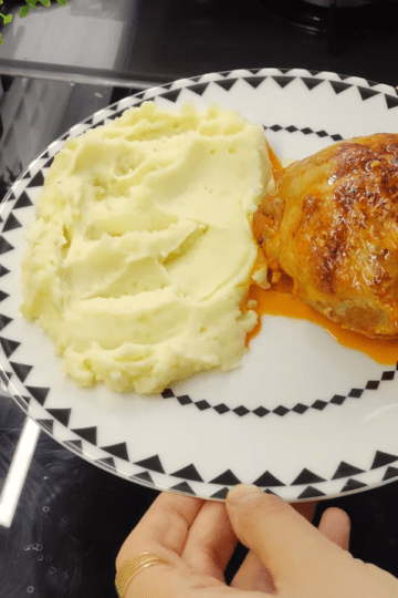 A beautifully roasted Piliç Topkapı chicken bundle served on a bed of creamy mashed potatoes with a rich tomato sauce glaze.