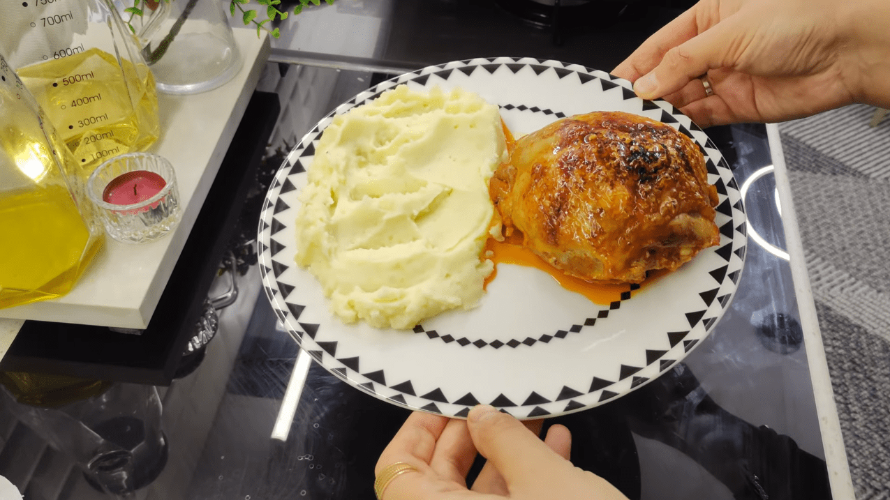 A beautifully roasted Piliç Topkapı chicken bundle served on a bed of creamy mashed potatoes with a rich tomato sauce glaze.