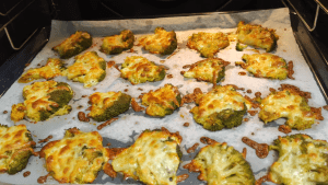 The cheesy broccoli roasting inside the oven, showing the cheese melting and turning golden brown.