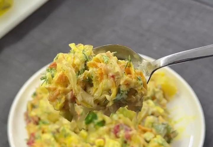 A vibrant and creamy Turkish potato salad served in a bowl, featuring a golden curry-yogurt dressing, diced roasted red peppers, sweet corn, and garnished with fresh dill.