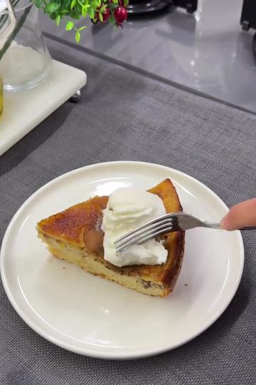 A slice of caramelized peach upside-down cake served with vanilla ice cream on a plate.
