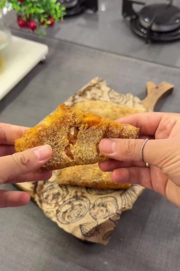 A plate of golden-brown crispy pizza rolls (börek) with a breadcrumb coating.