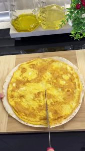 Flipping the egg-covered tortilla so the fluffy egg side is facing up on a plate.