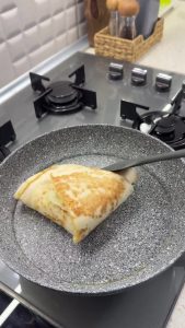 Folding the four sections of the tortilla clockwise into a neat, layered triangle shape.