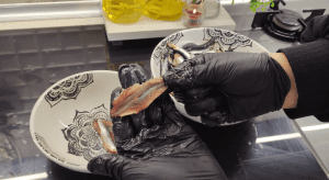 A close-up view of cleaning fresh anchovies and carefully removing the bones for the stuffed fish recipe.