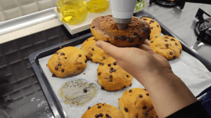 Injecting chocolate spread into the baked bun and dusting it with powdered sugar