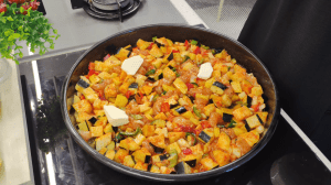 Mixing the chicken and vegetables with the sauce and placing small butter pieces on top.