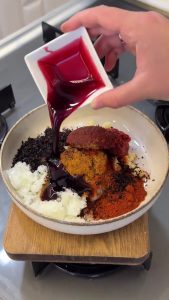 Preparing the spicy sauce by mixing tomato paste, garlic, spices, and pomegranate molasses.