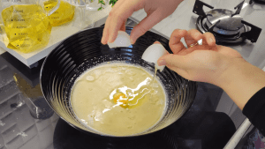 Whisking vegetable oil, egg, and the yeast mixture in a large mixing bowl.