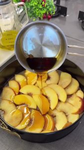 Drizzling hot caramel sauce and sprinkling chopped walnuts over the arranged peach slices.