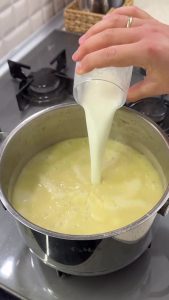 Adding a cup of room-temperature milk to the blended zucchini soup to enhance its creaminess.