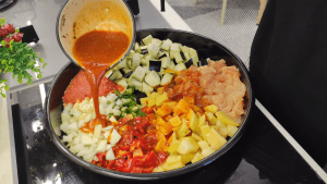 Whisking together tomato paste, oil, water, and dried thyme in a small bowl for the sauce.