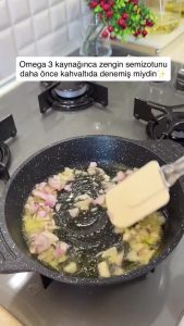 Sautéing small diced onions in a pan with extra virgin olive oil.