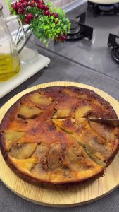 The final caramelized peach upside-down cake inverted on a plate and served with vanilla ice cream.