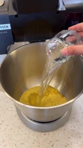 Soaking fine bulgur in a large bowl with boiling water for the base of the recipe.