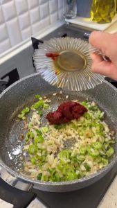 Mixing Turkish tomato and red pepper pastes with sautéed vegetables for the pilaf base.