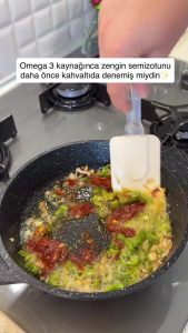 Mixing a teaspoon of tomato paste with sautéed onions and peppers.