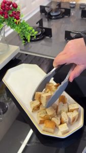 Slicing and tearing the cooked meat roll into thin shavings for the İskender presentation.