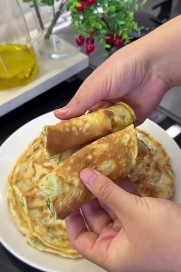 A stack of traditional Black Sea Kaygana pancakes garnished with fresh herbs and served with Turkish tea.