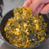 A healthy skillet of sautéed purslane and peppers topped with a cooked egg.