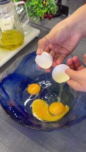 Whisking eggs, sugar, and vanilla in a mixing bowl until the mixture becomes pale and foamy.