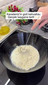 Whisking flour, milk, and salt in a mixing bowl to create a smooth base for the pancake batter.