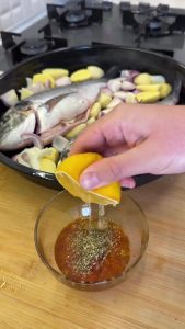 Mixing olive oil, red pepper, thyme, garlic, and lemon juice for the fish marinade.