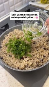 Sprinkling finely chopped fresh dill over the cooked aromatic rice before resting.