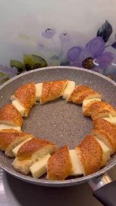 Tucking slices of kashar cheese or mozzarella between the simit pieces in the pan.
