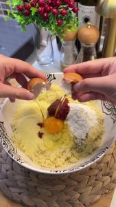 Adding semolina, flour, an egg, and tomato-pepper paste to the softened bulgur.