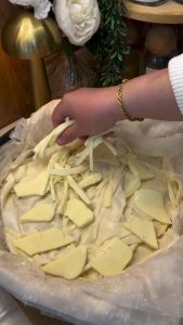Adding a mix of shredded kashar and string cheese over the yufka layer.