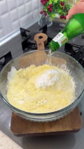 Pouring cold sparkling mineral water into the dry flour mix to create a crispy batter.