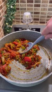 Adding a tablespoon of red pepper paste to the sautéed onions.