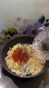 Adding salt, paprika, black pepper, and red pepper flakes to the caramelized onions.