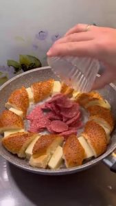 Adding spicy Turkish sucuk (sausage) slices to the melted butter in the center.