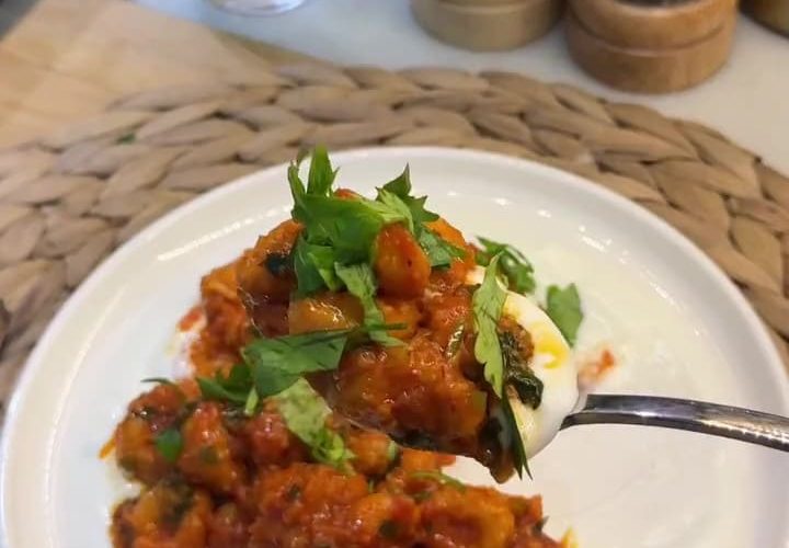 A platter of Turkish Fellah Köftesi meatballs in tomato sauce served over garlic yogurt.