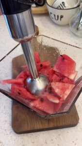 Blending fresh red watermelon chunks into a smooth puree in a high-speed blender.