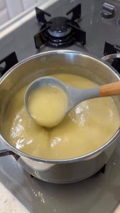 Using a hand immersion blender to create a smooth, velvety texture in the soup pot.