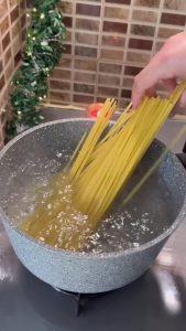 Boiling penne pasta in a large pot of salted water.