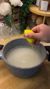 Boiling sugar, water, and lemon juice in a pot to make Turkish cake syrup.