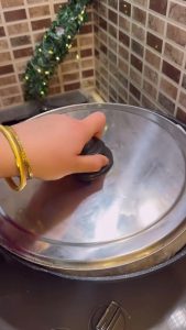 Lifting the paper to show the chicken cooking in its own natural juices.