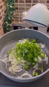 Slicing fresh button mushrooms and julienning onions for a sauté.