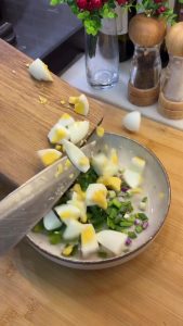 Finely chopping fresh parsley and scallions to add to the egg salad.