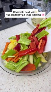 Chopping eggplants, zucchinis, and peppers into even pieces on a cutting board.